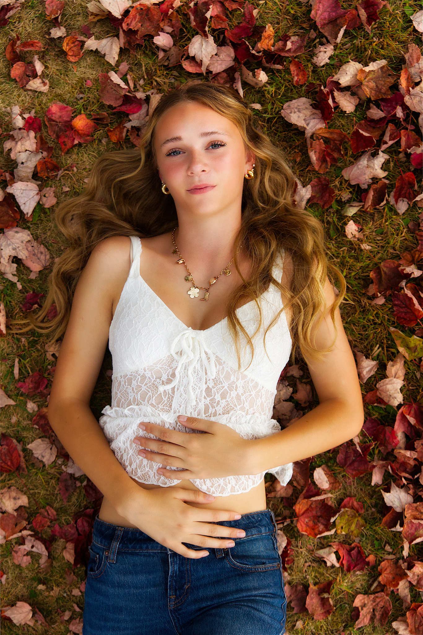 Senior portrait — young woman in autumn leaves